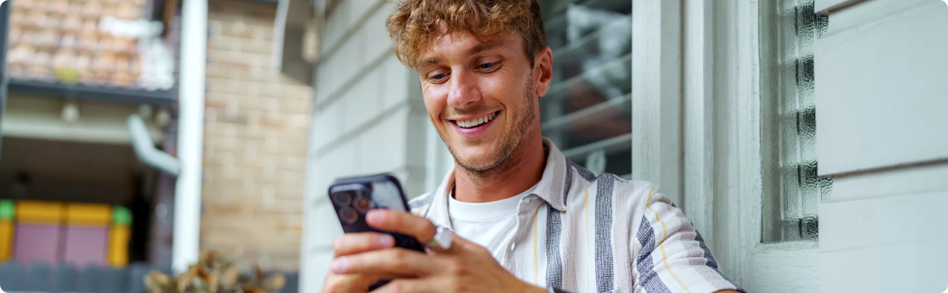 Smiling man using mobile phone to get more information about Cell C Home LTE Fixed Wi-Fi